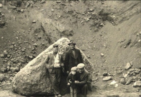 Historisches Foto: Gründerfamilie von REITZ Natursteintechnik vor großem Granitblock im Steinbruch.