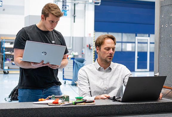 Zwei Mitarbeiter bei REITZ Natursteintechnik arbeiten gemeinsam an technischen Projekten am Laptop. Initiativbewerbung und vielfältige Einsatzbereiche.