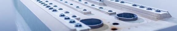 Detailansicht eines Maschinenbauteils aus UHPC mit integrierten Gewindeeinsätzen, Passflächen und runden Bohrungen