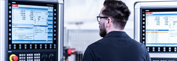 Mitarbeiter bei der CNC-Steuerung moderner Fertigungsmaschinen. Arbeiten in der Präzisionstechnik und Fertigung bei REITZ Natursteintechnik.