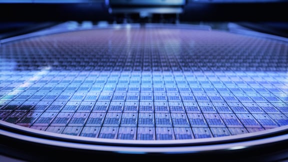 Nahaufnahme eines kreisrunden Siliziumwafers auf Bearbeitungstisch