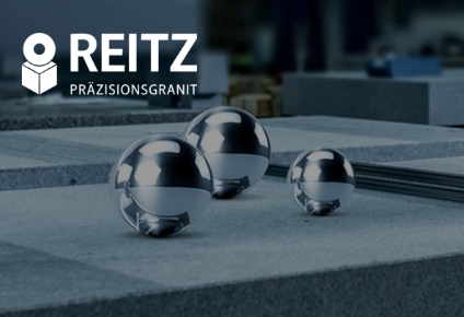 Drei glänzende Stahlkugeln auf fein bearbeitetem Präzisionsgranit